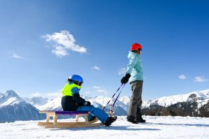 Bei Skiferien in Scuol mit Kindern ist ein Ausflug mit dem Schlitten ein grosses Highlight